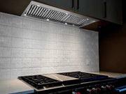 Built-in range hood installed in a professional kitchen with 20-inch deep baffle filters for full cooktop protection
