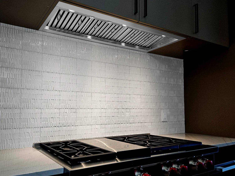 Built-in range hood installed in a professional kitchen with 20-inch deep baffle filters for full cooktop protection