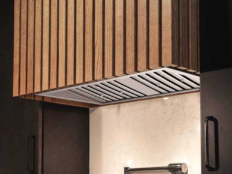36 Inch 700 CFM Range Hood Insert installed beneath custom wood cabinetry, highlighting its flush profile and stainless steel baffle filters