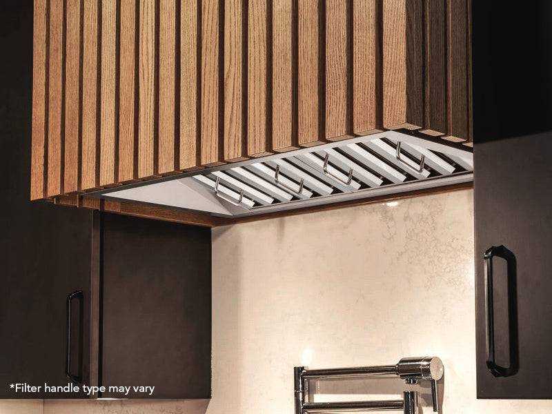 Custom kitchen installation of a range hood insert featuring stainless steel baffle filters and integrated task lighting within a modern wood slat hood enclosure