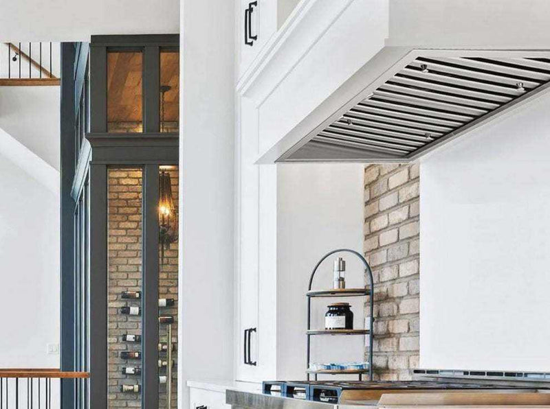 Modern white kitchen with VICTORY Q5 flush-mounted stainless steel insert range hood installed in custom cabinetry above pro-style cooktop